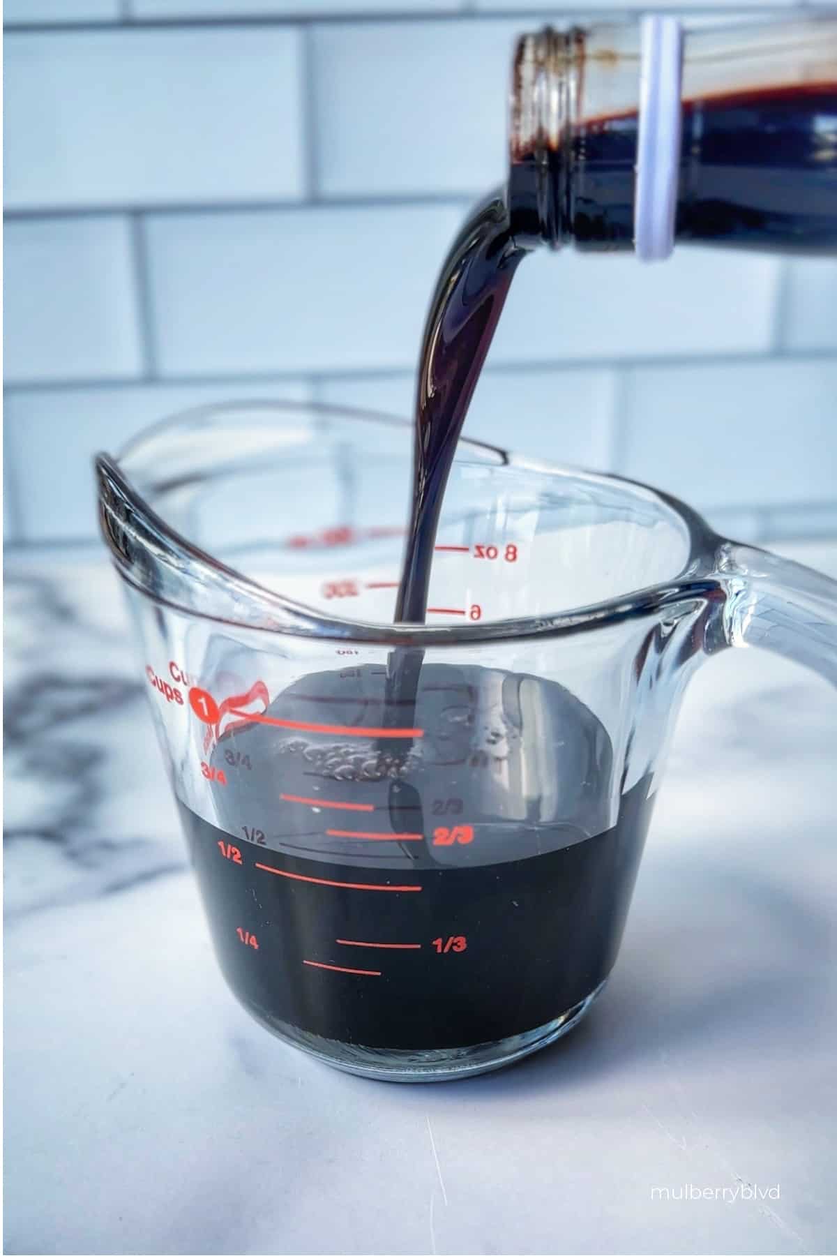 Pomegranate molasses being poured into measuring vessel