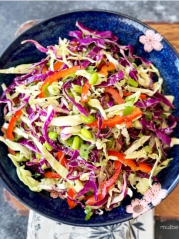 Superfood kelp noodle salad with cabbage and sesame dressing in blue bowl.