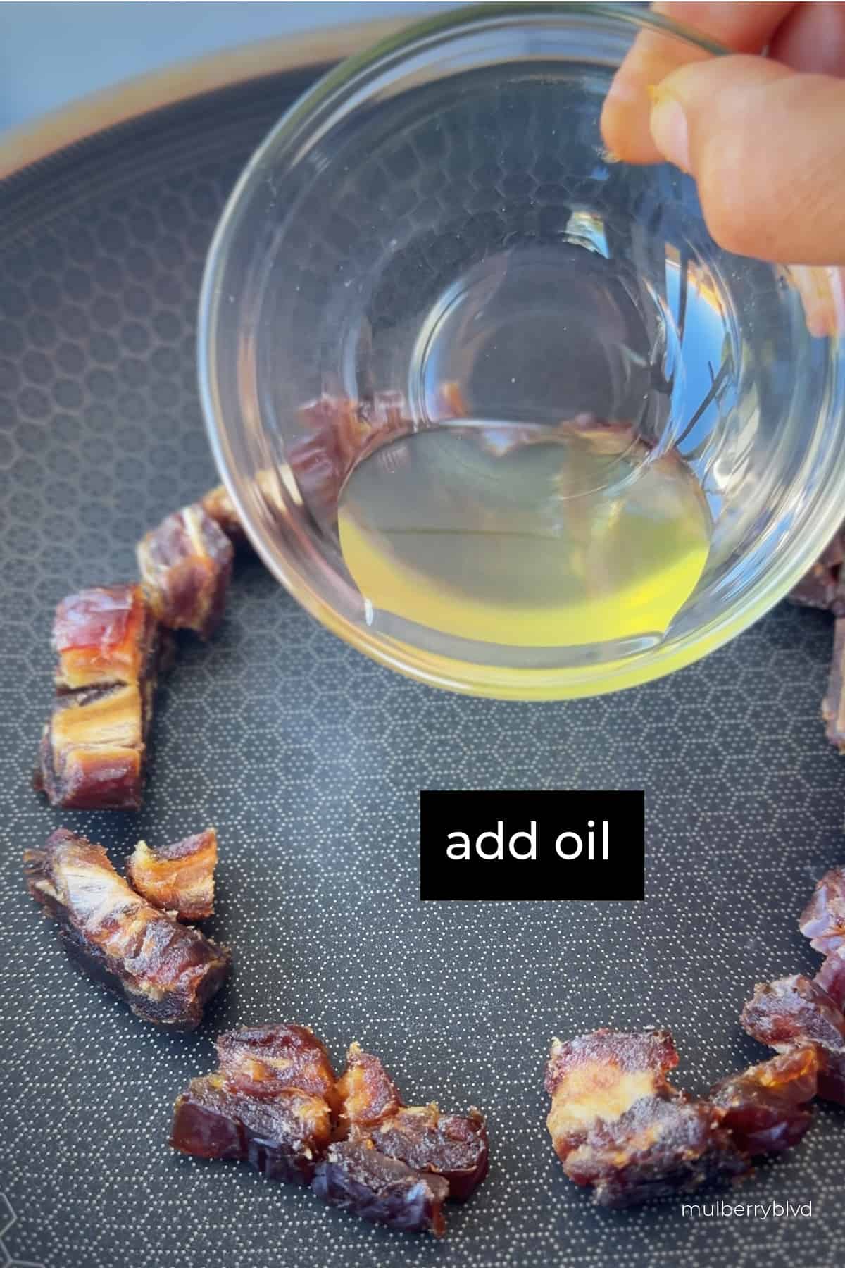 This is an image of chopped up dates arranged around a pan, with a hand holding a small bowl with oil in it, and the caption saying "add oil".
