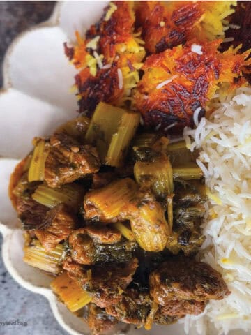 This is a picture of Delicious Persian Celery Stew or Khoresh Karafs on plate with white rice and tahdig